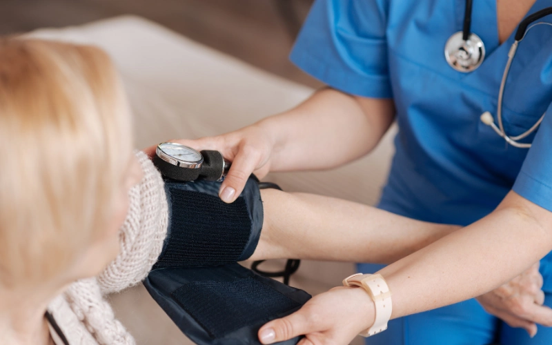 A nurse helping an older lady get out of bed