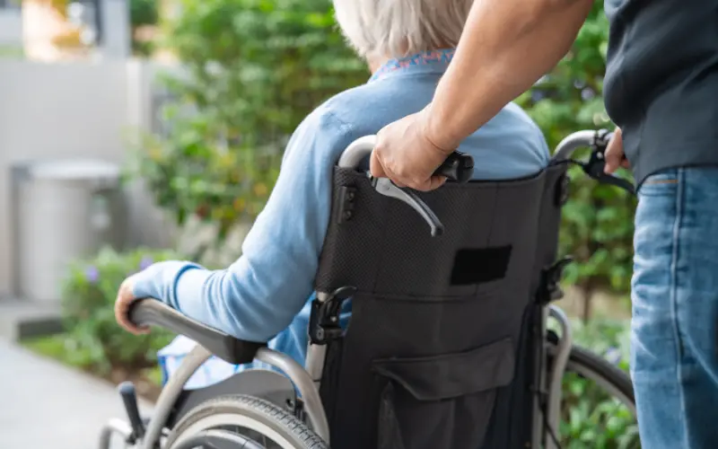 A man pushing an older lady in her wheelchair